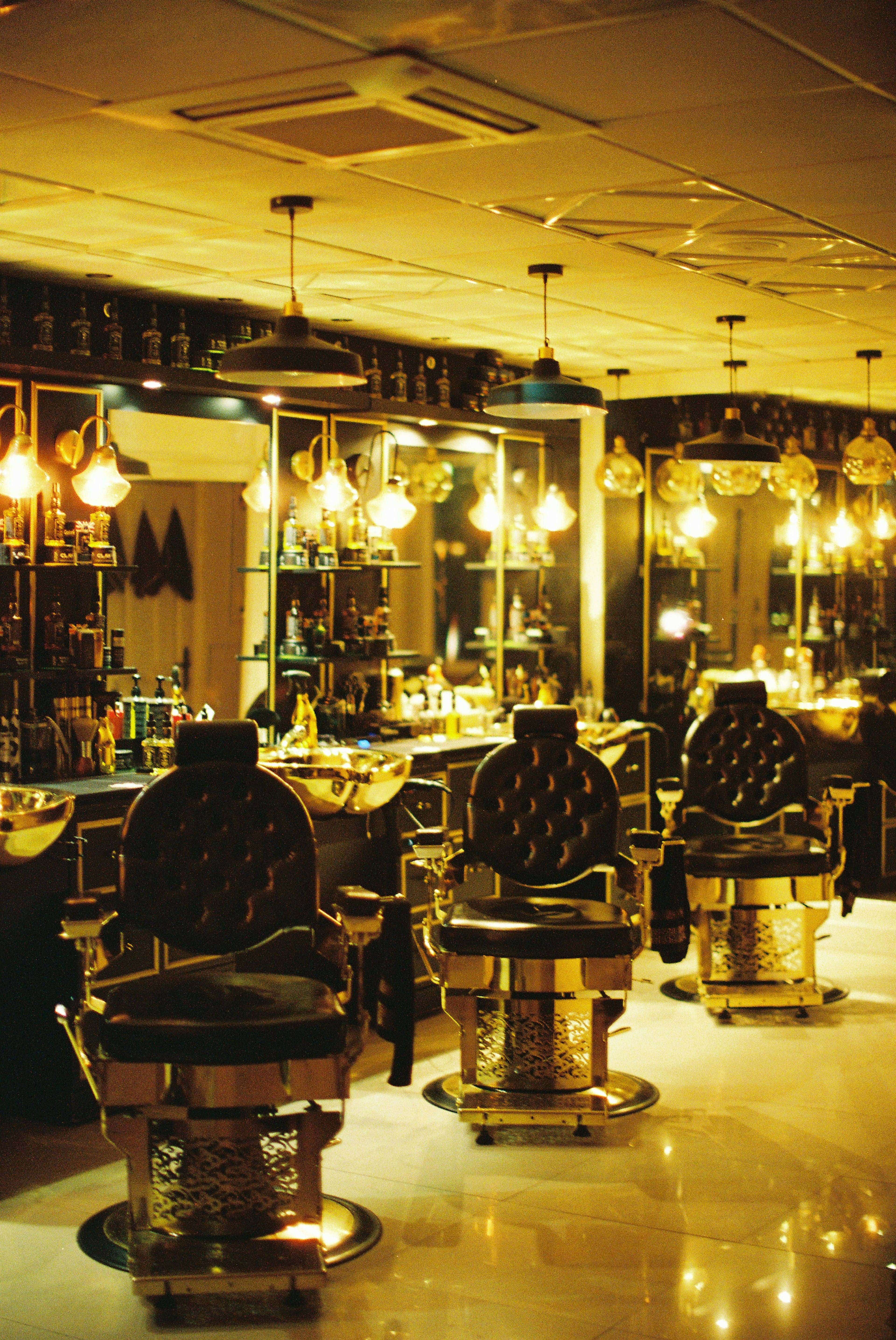 Luxurious barber chairs and sinks in a dimly lit salon