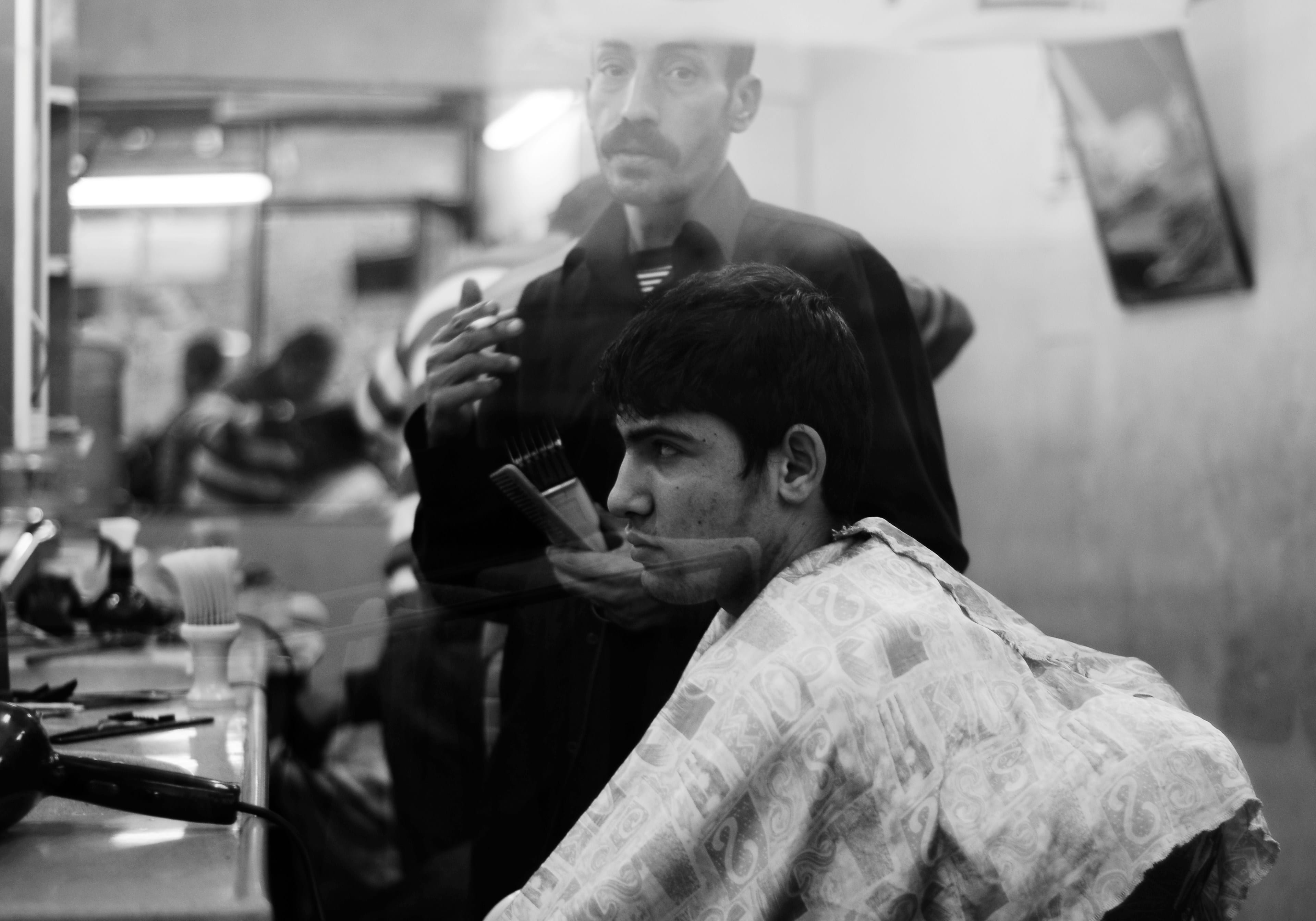 Barber working with a client in a moody shop moment
