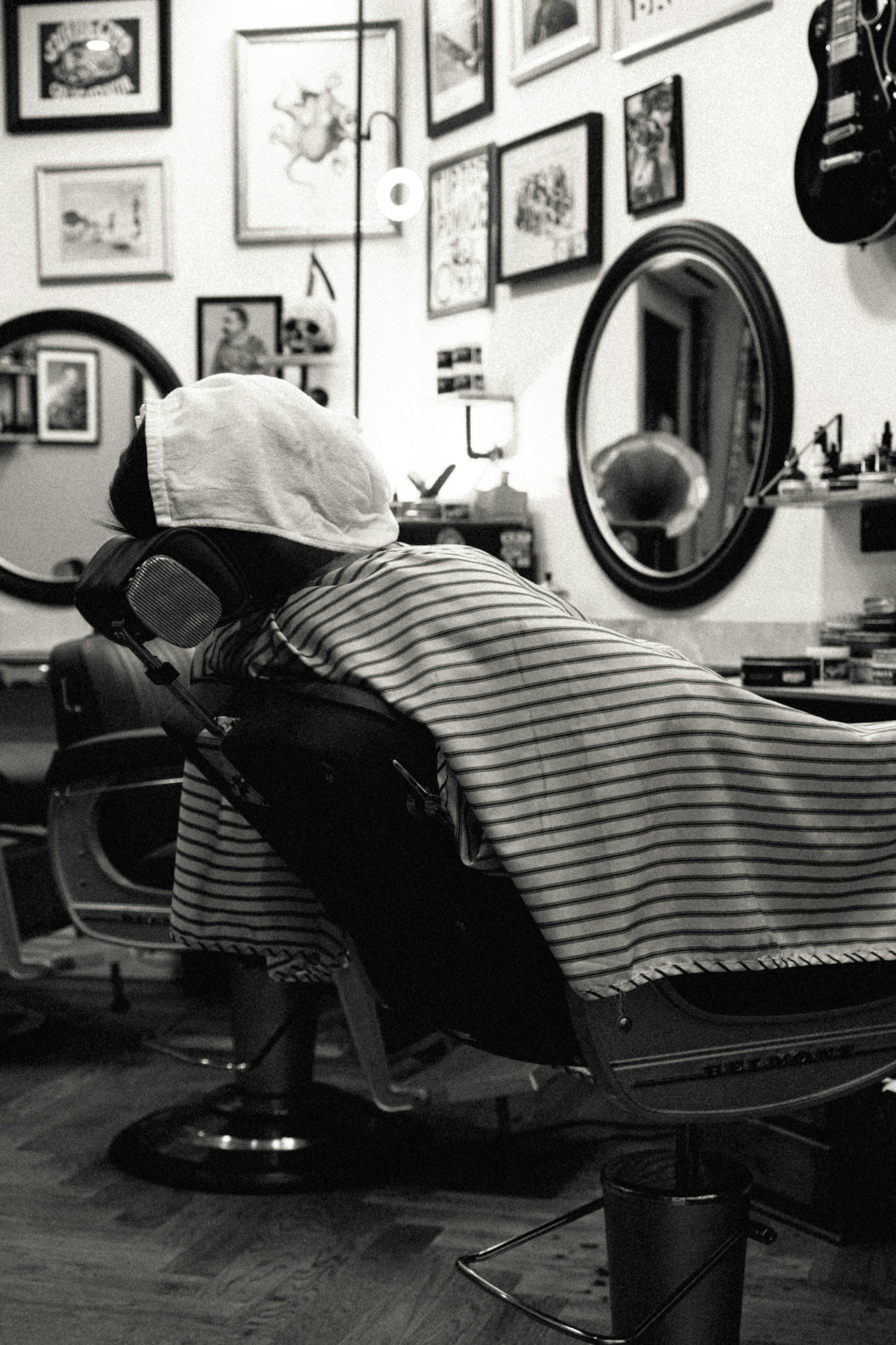 Person seated in front of a mirror inside a moody salon