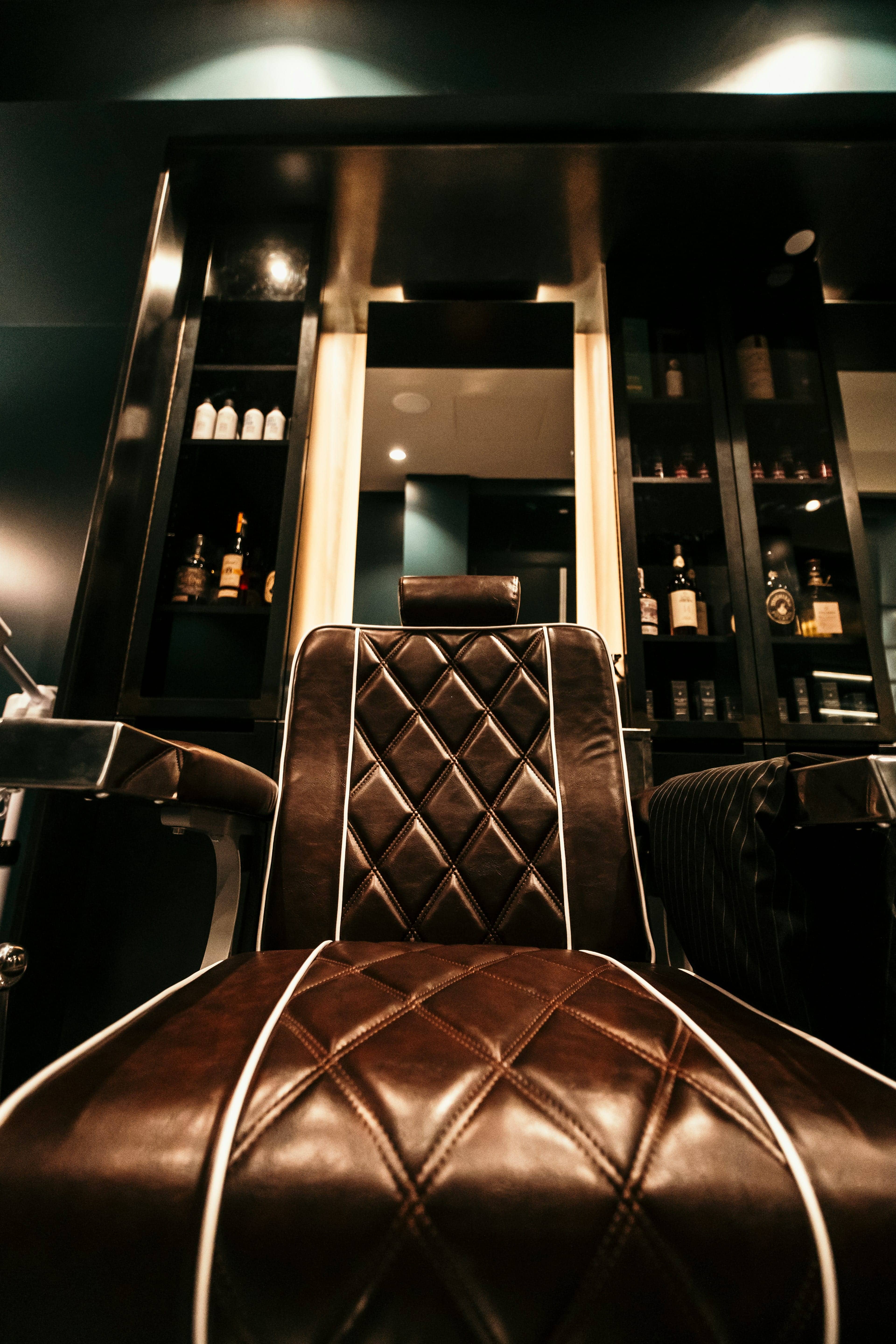 Brown leather barber chair in a warm classic barbershop interior
